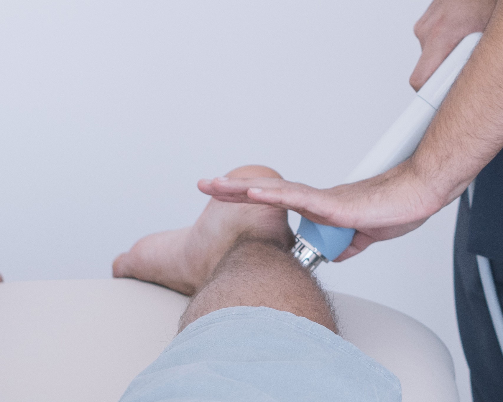 the physiotherapist treating a man using equipment for radio therapy
